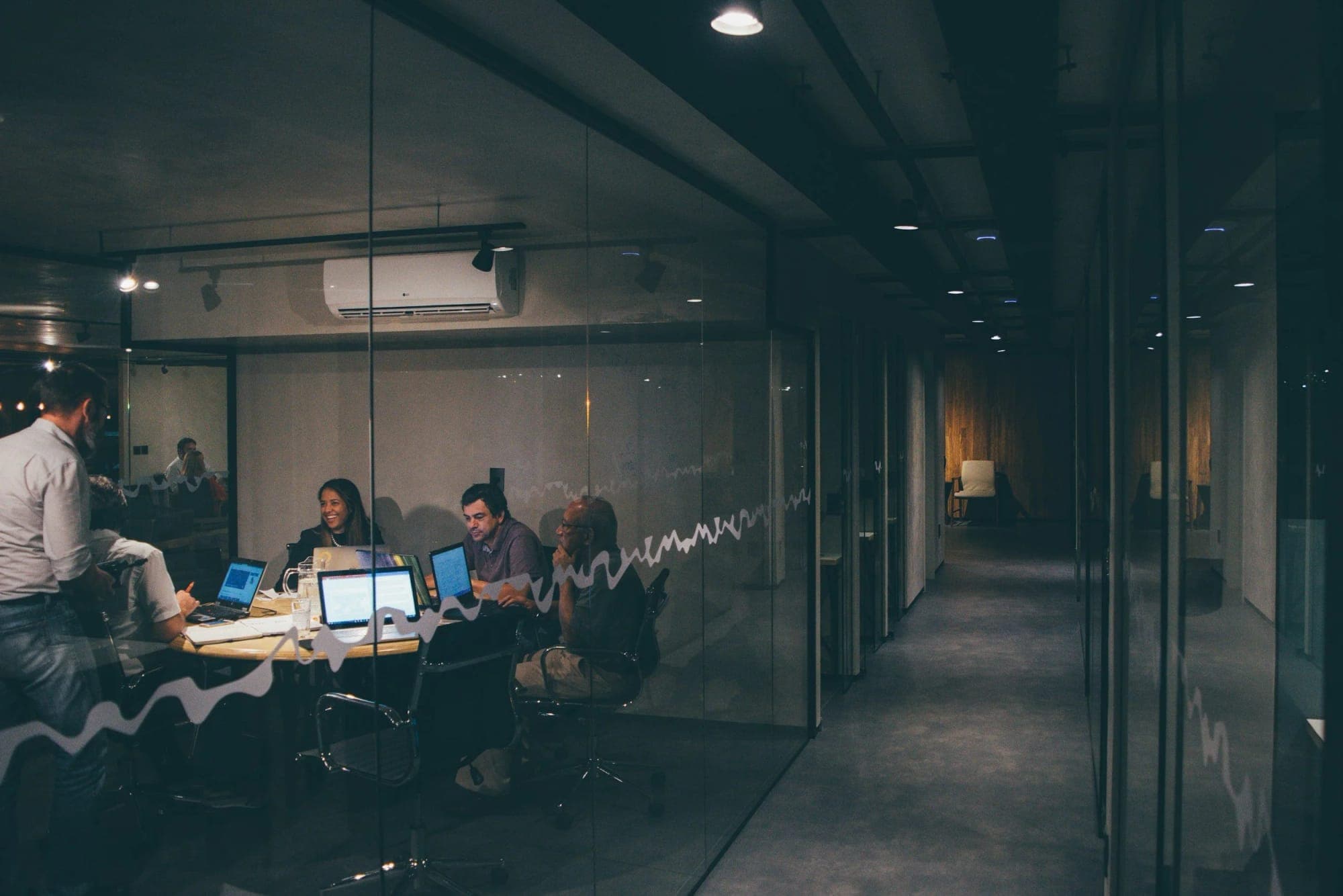 Team working at laptops in a dark office