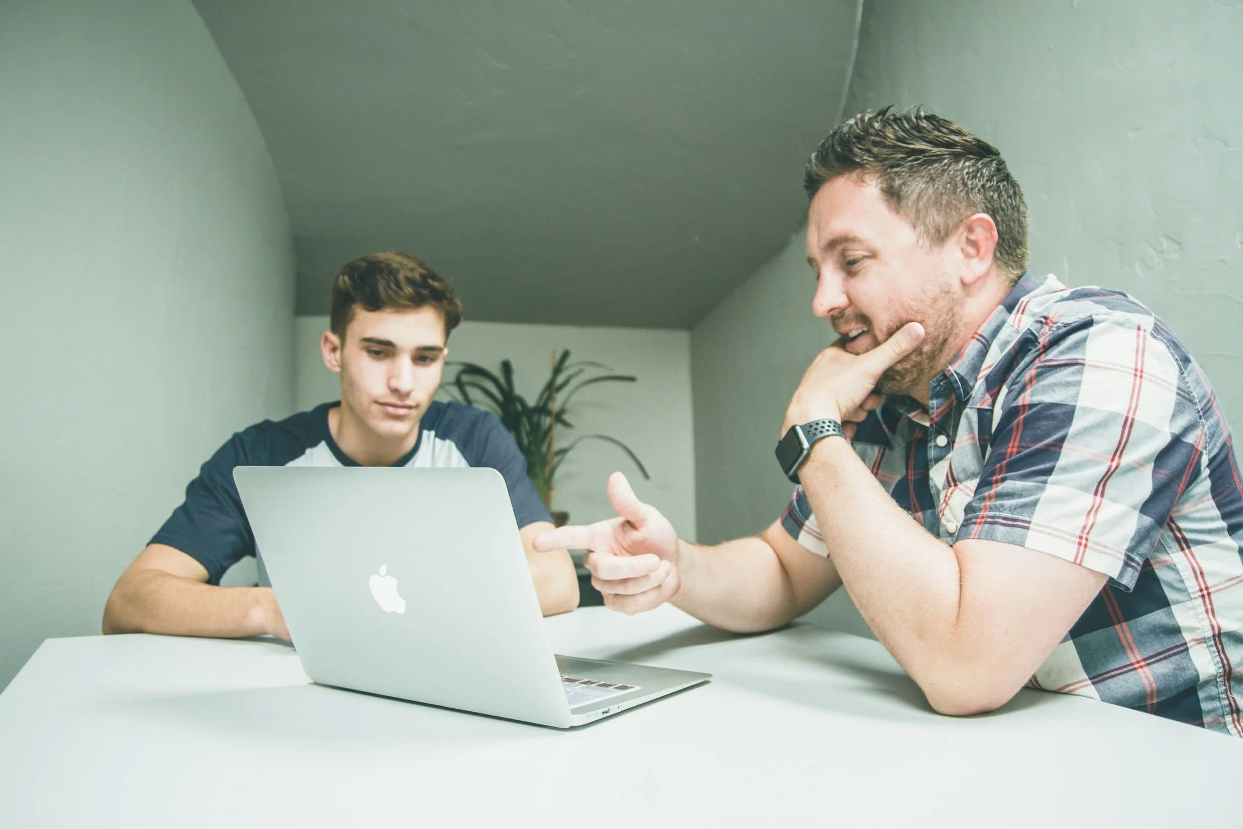 Two colleagues talking at a laptop