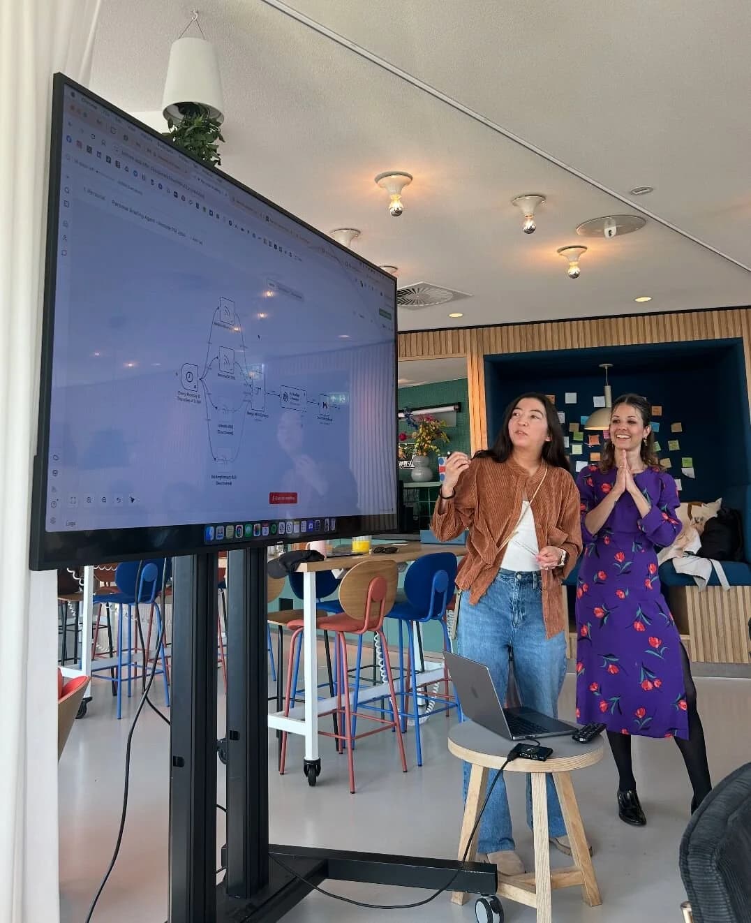 Rafaela Buena and a co-host presenting an AI session next to a screen