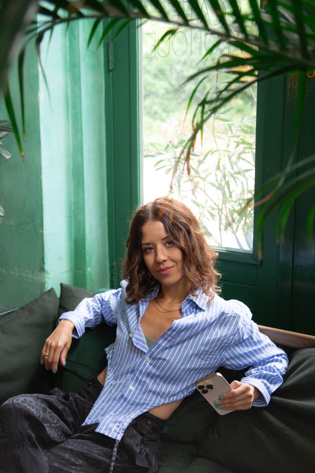 Rafaela Buena smiling on a green sofa