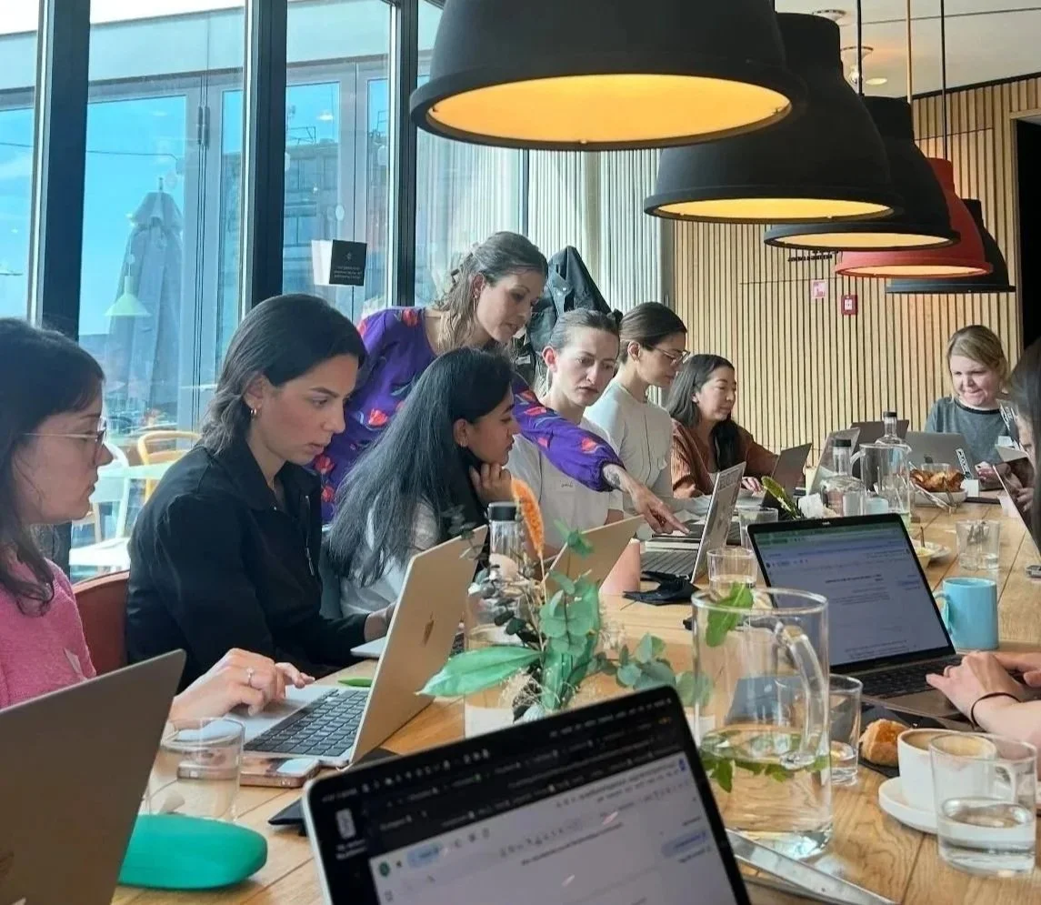 Participants working on laptops during an AI workshop by Rafaela Buena